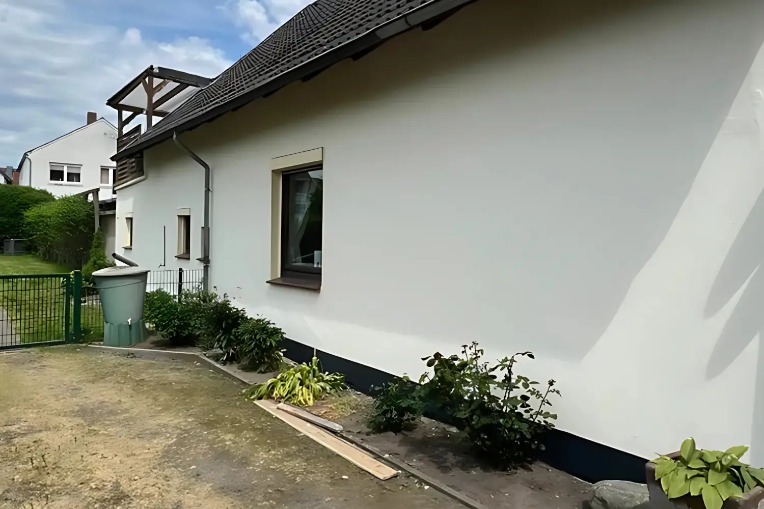 Frisch sanierte, weiße Fassade eines Einfamilienhauses in Garrel