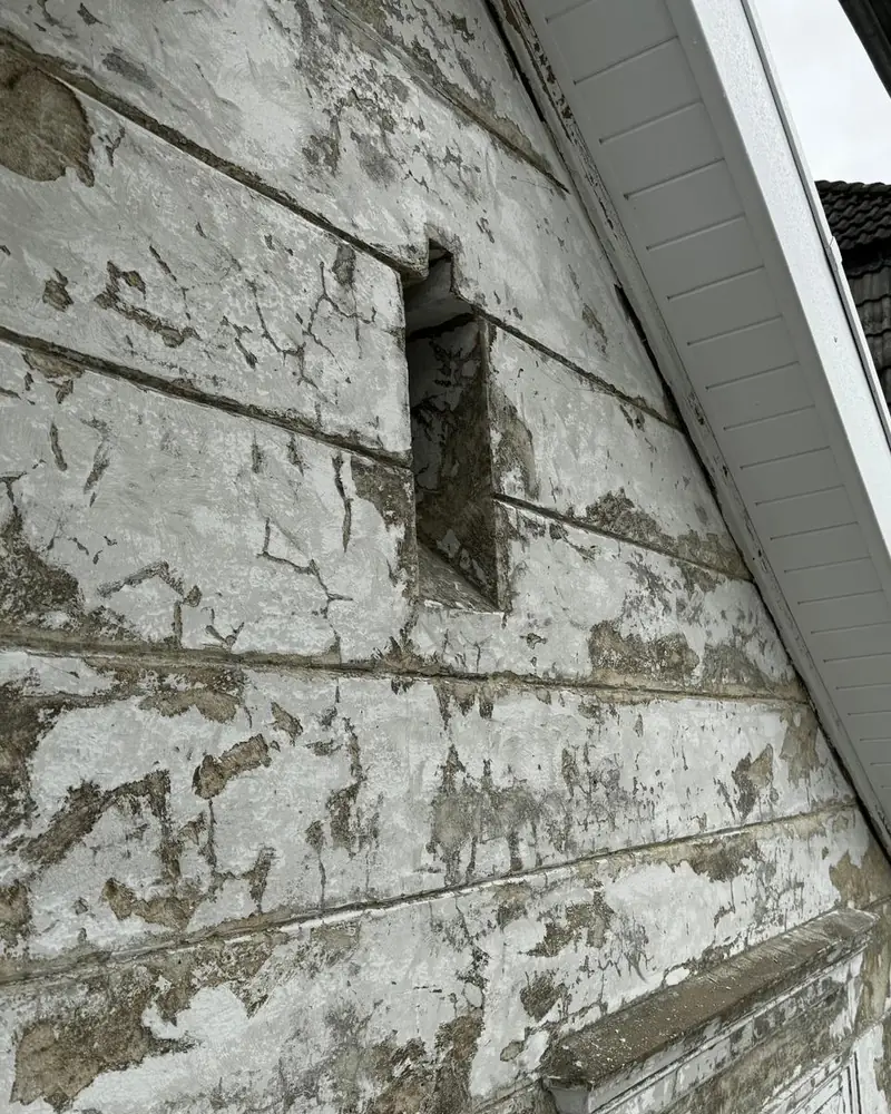 Giebelwand, auf der der alte Anstrich flächig abblättert